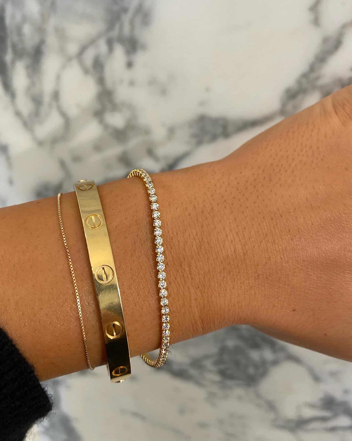 Closeup of the Cartier love bracelet and a dimaond tennis bracelet