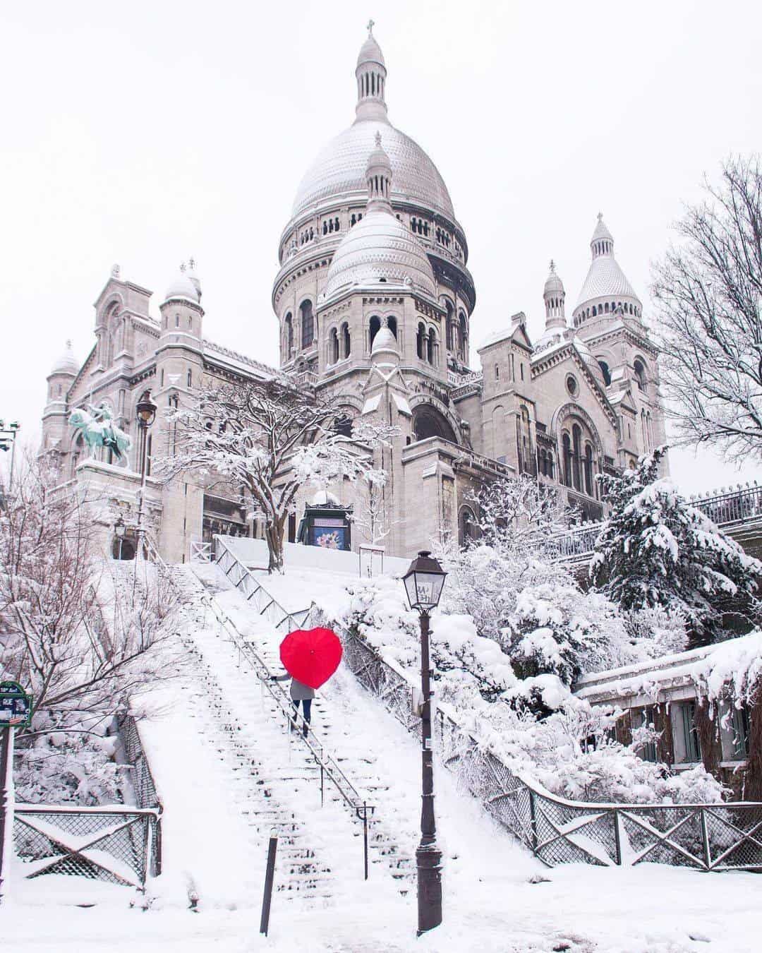 Red heart umbrella in the snow in paris